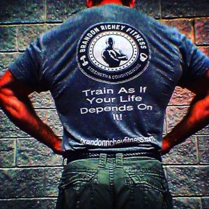 Man standing showing the back of his t-shirt with the Brandon Richey Fitness ghostman logo on display. 