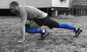 Man in a start position getting ready to sprint on a field. 