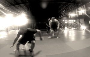 Guys performing agility drills under the watchful eye of a strength coach