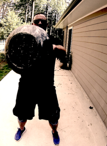 Man performing a kettlebell swing and the image has captured the end of the kettlebell at the peak of the swing at the lifter's chest height.