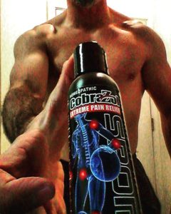 CobraZol Sport Head Sports Ambassador Brandon Richey holding a 4 oz. black bottle of CobraZol Sport cream. 