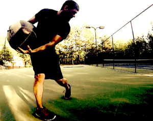 Rotational Medicine Ball Throw by torquing the torso and bringing the ball across the body to throw it out in front.