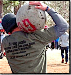 Man carrying a stone on his shoulder during strongman lifting. 