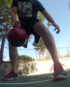 A ground up point of view of a man lowering a kettlebell towards the ground during a single arm kettlebell row. 