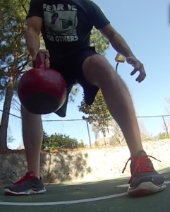 Man performing a set of single arm bent over row with a kettlebell. 