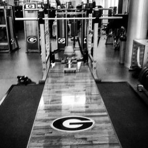 Black and white image of the olympic lifting platform at the University of Georgia Football weight room. 