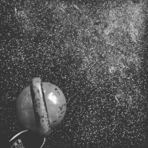 Black and white photo of a top view looking down at a kettlebell on the floor. 