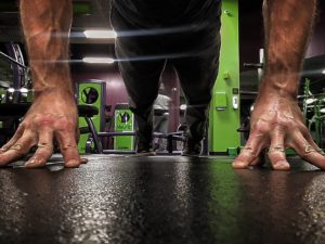 Ground view of a strong man doing fingertip push-ups. 