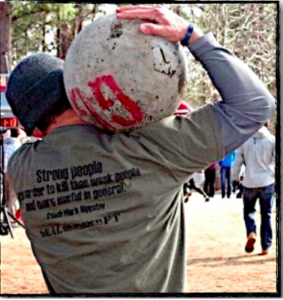 Man carrying an atlas stone on his shoulder displaying functional fitness